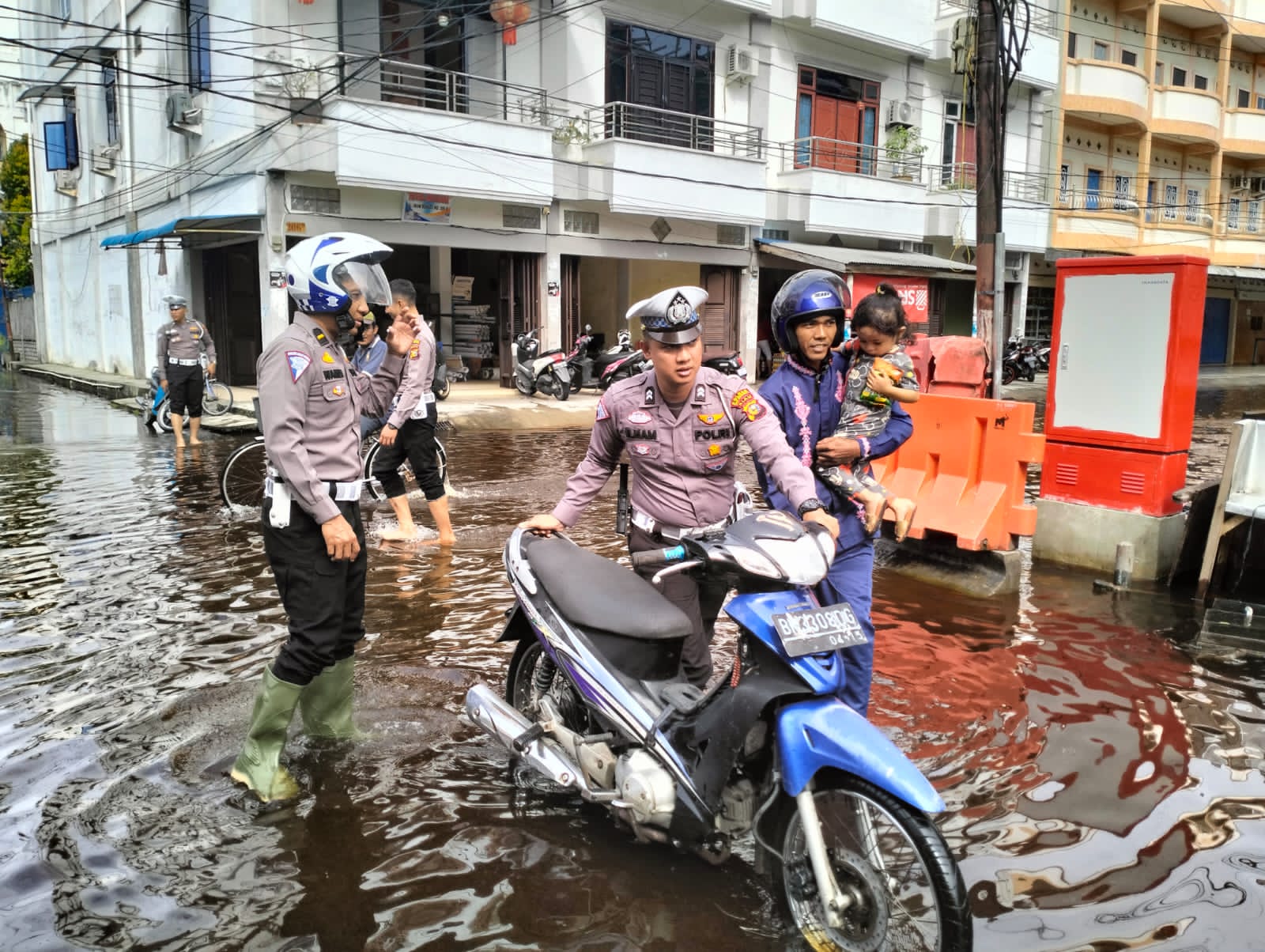 Peduli Keselamatan, Personel Satlantas Bantu Warga Lewati Jalan Terendam Banjir