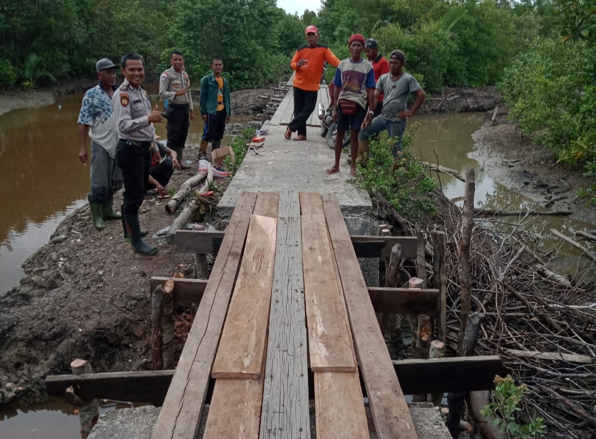 Bhabinkamtibmas Desa Kedabu Rapat Bantu Perbaiki Jembatan Rusak karena Abrasi