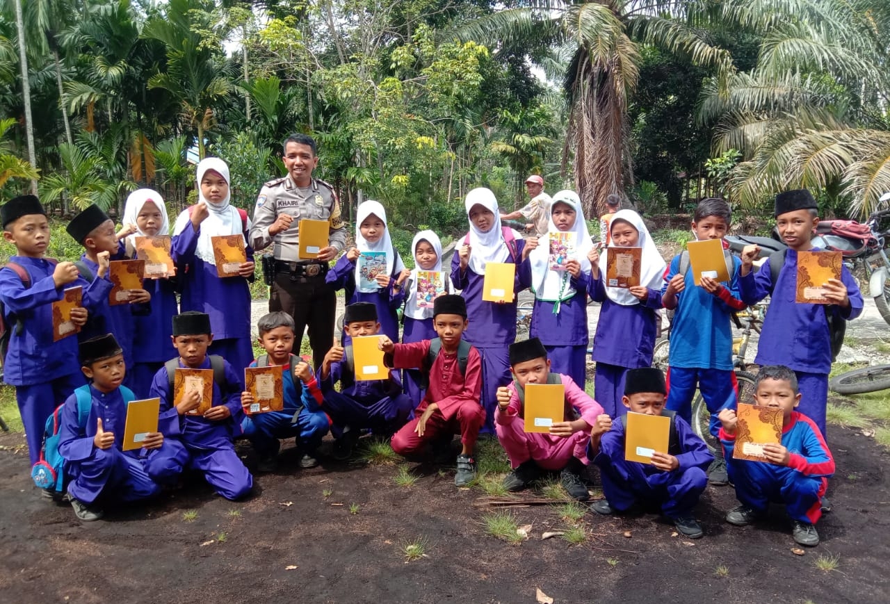 HUT RI ke-77, Bhabinkamtibmas Desa Sendaur Bagikan Buku Tulis pada Anak-anak
